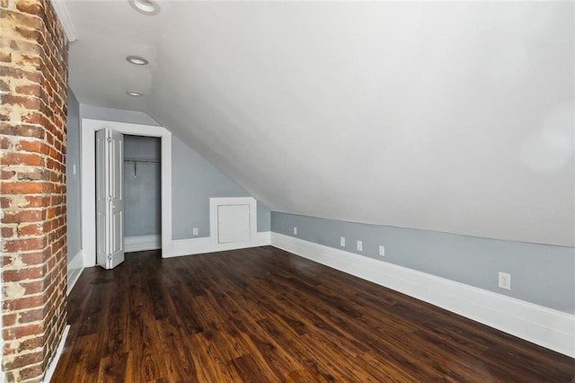 additional living space featuring dark hardwood / wood-style flooring and vaulted ceiling