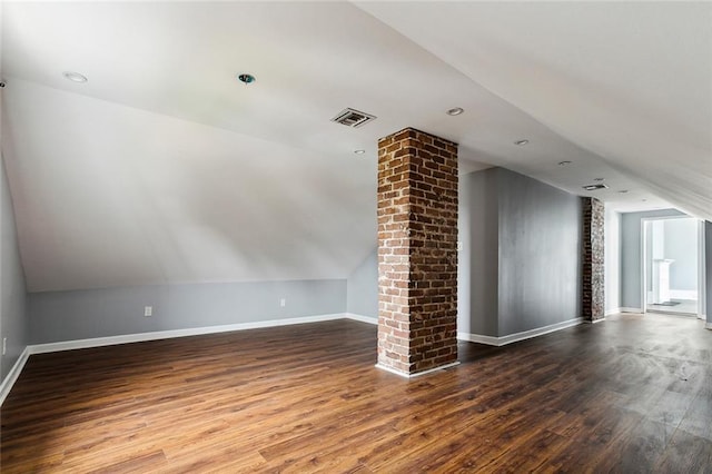 unfurnished living room with wood-type flooring and vaulted ceiling