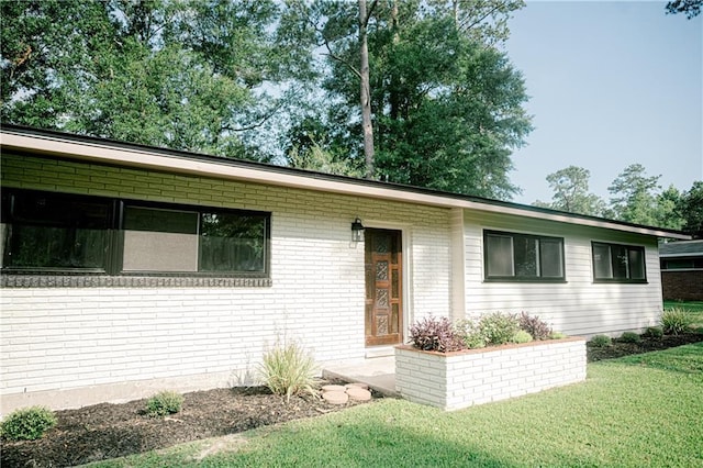 single story home featuring a front lawn