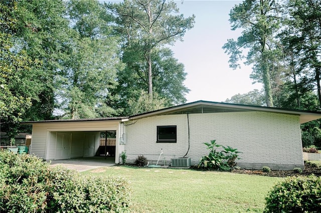 rear view of house featuring central AC unit, a yard, and a carport