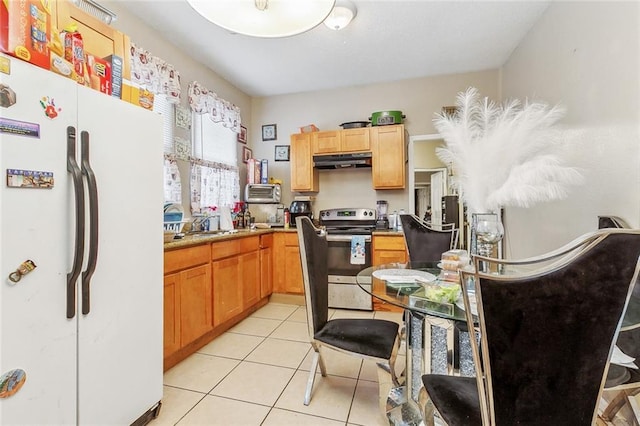 kitchen with light tile patterned flooring, electric stove, and white fridge