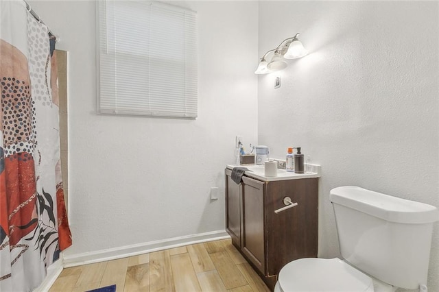 bathroom featuring toilet, vanity, hardwood / wood-style flooring, and a shower with curtain