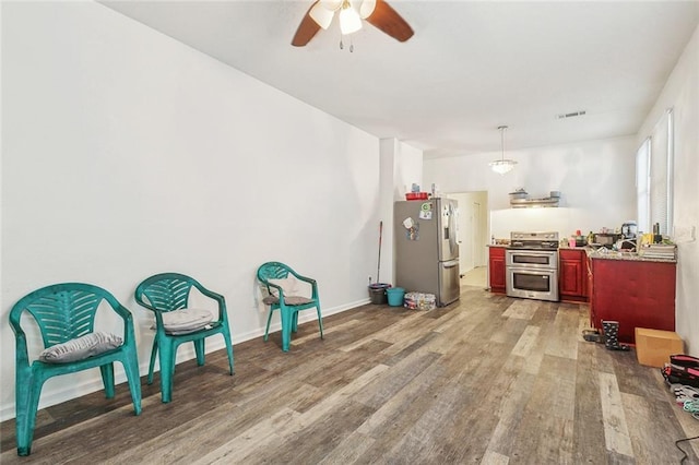 kitchen with appliances with stainless steel finishes, ceiling fan, and hardwood / wood-style floors