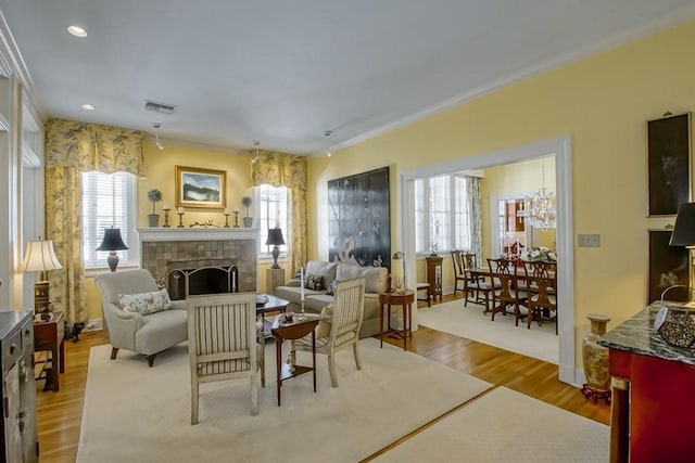 living room featuring a tiled fireplace and light hardwood / wood-style floors