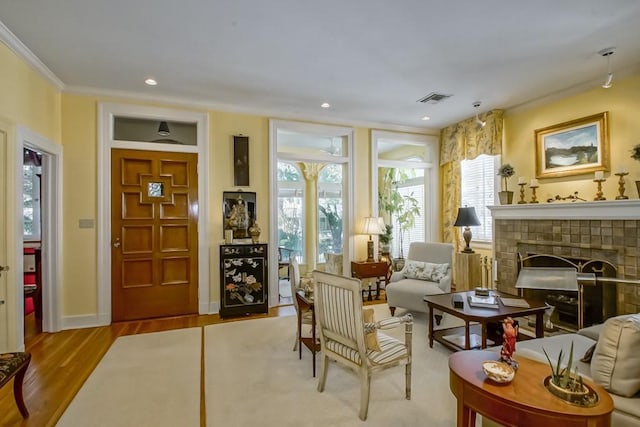 sitting room with light hardwood / wood-style flooring, crown molding, and a fireplace