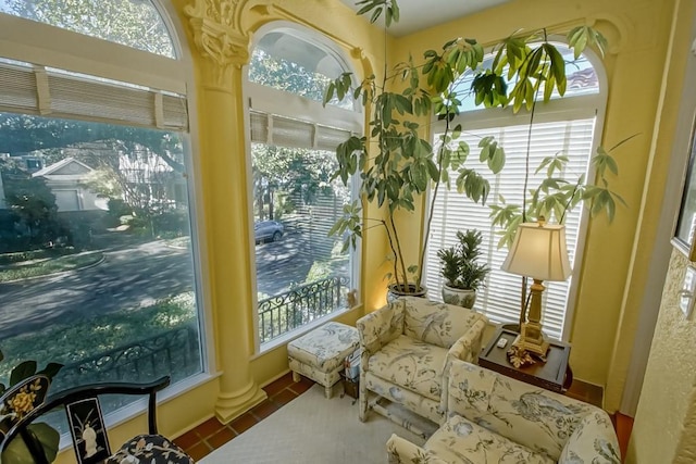 sunroom featuring ornate columns and plenty of natural light