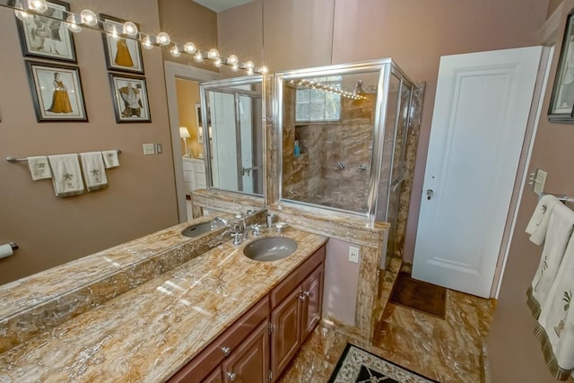 bathroom featuring a shower with door and vanity