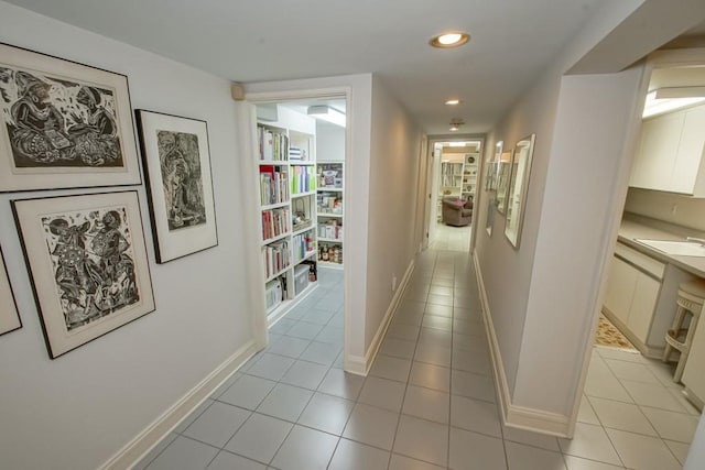 hallway featuring light tile patterned floors and sink