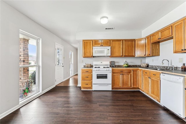 kitchen with sink, white appliances, and dark wood-type flooring