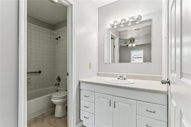 full bathroom featuring tile patterned flooring, ceiling fan, toilet, vanity, and tiled shower / bath combo