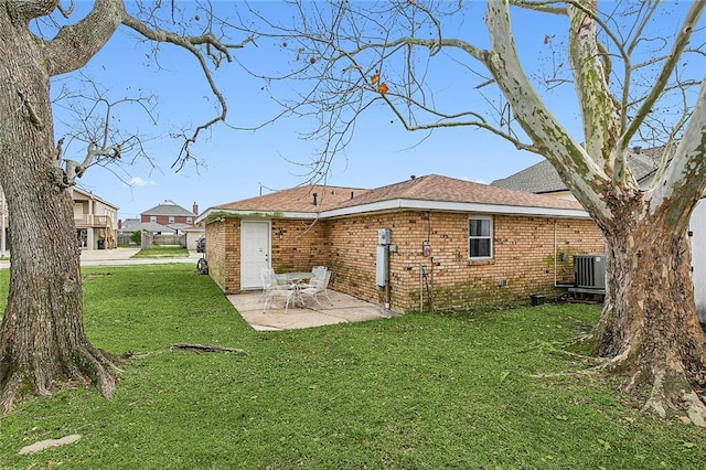 back of house featuring a lawn, cooling unit, and a patio area