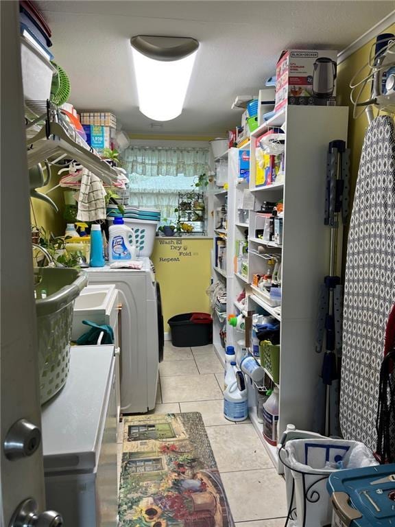 laundry room with ornamental molding, washer / clothes dryer, and light tile patterned flooring