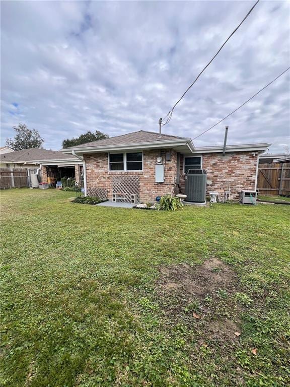 back of house with cooling unit and a lawn