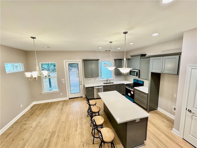 kitchen featuring decorative light fixtures, stainless steel appliances, a notable chandelier, decorative backsplash, and a kitchen island