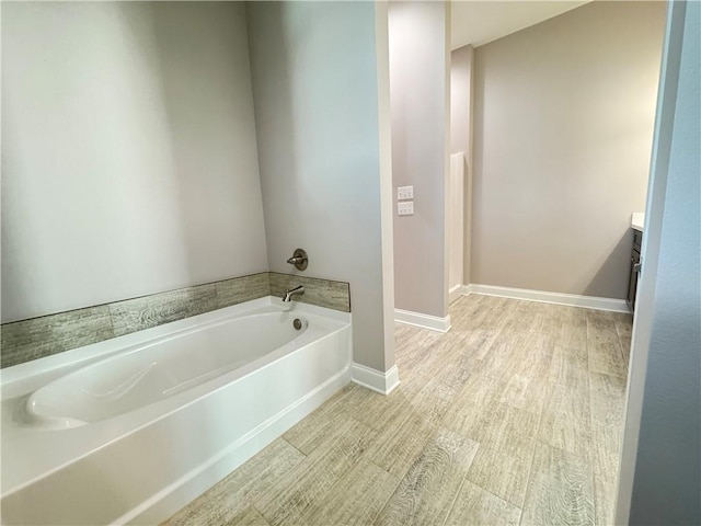 bathroom featuring a bathtub, vanity, and wood-type flooring