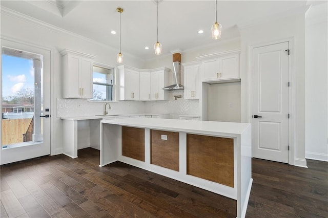 kitchen with white cabinetry, decorative backsplash, a center island, and wall chimney exhaust hood