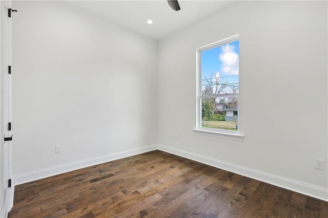 empty room with ceiling fan and dark hardwood / wood-style flooring