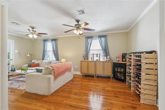 living room with ceiling fan, crown molding, a wealth of natural light, and hardwood / wood-style floors