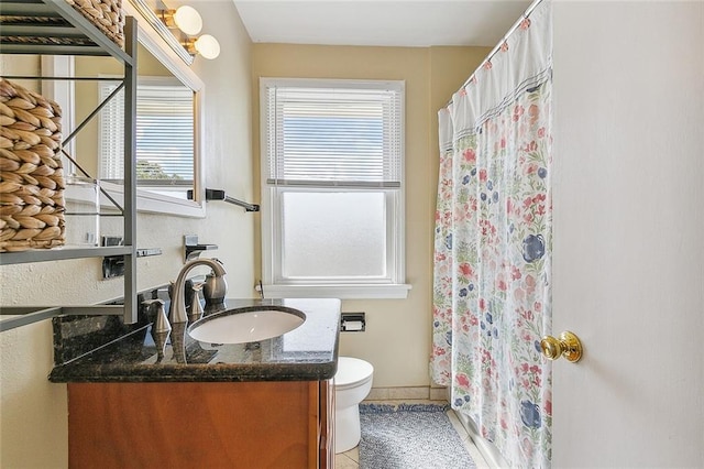 bathroom with toilet, tile patterned floors, walk in shower, and vanity