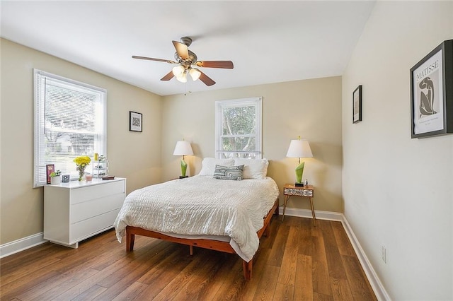 bedroom featuring ceiling fan, multiple windows, and dark hardwood / wood-style floors