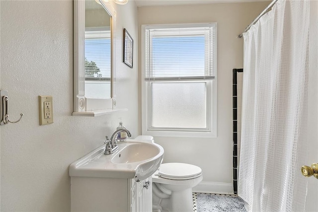 bathroom featuring toilet, tile patterned floors, walk in shower, and vanity