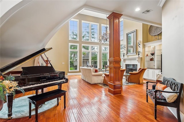 sitting room featuring light wood-type flooring and ornate columns