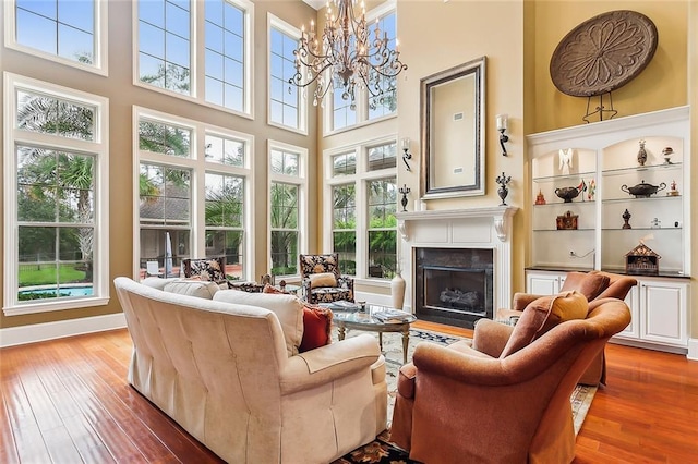 living room with a high ceiling, an inviting chandelier, and hardwood / wood-style floors