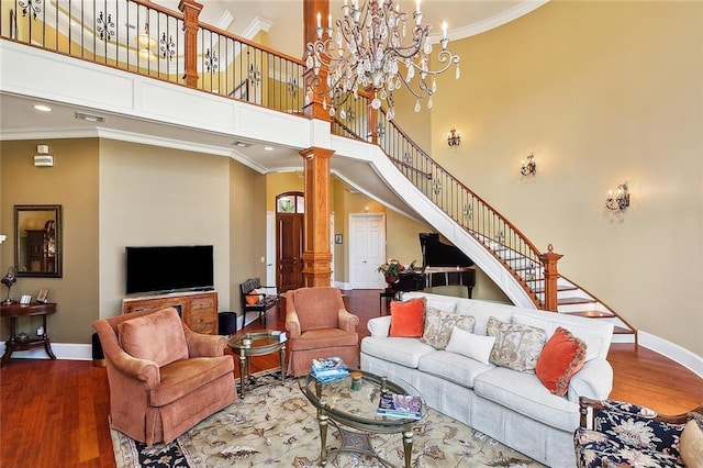 living room featuring ornate columns, hardwood / wood-style flooring, and crown molding