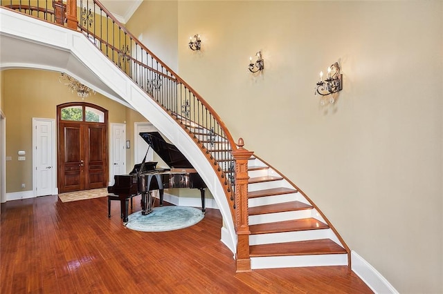 foyer entrance with a high ceiling, hardwood / wood-style flooring, and ornamental molding