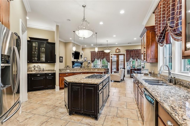 kitchen with sink, decorative light fixtures, a center island, a wealth of natural light, and appliances with stainless steel finishes