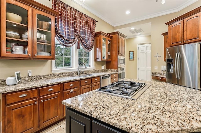 kitchen featuring stainless steel appliances, light tile patterned floors, ornamental molding, light stone counters, and sink