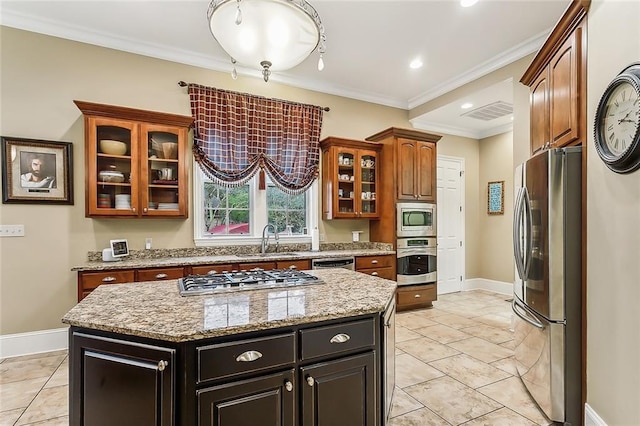 kitchen with sink, stainless steel appliances, ornamental molding, and a center island