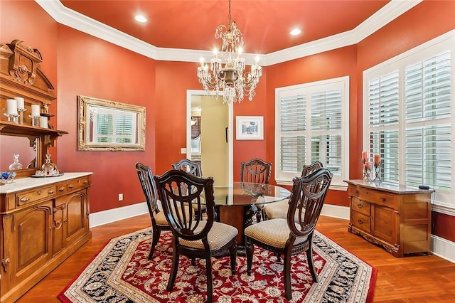 dining space featuring ornamental molding, light wood-type flooring, and an inviting chandelier