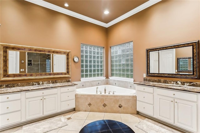 bathroom with crown molding, tile patterned floors, tiled tub, and vanity