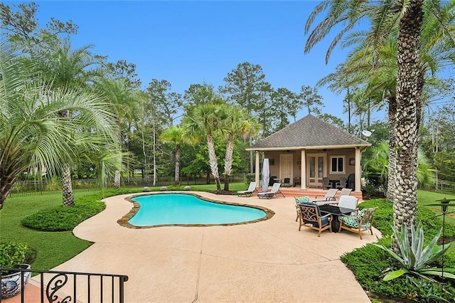 view of pool with a patio, french doors, and an outdoor structure