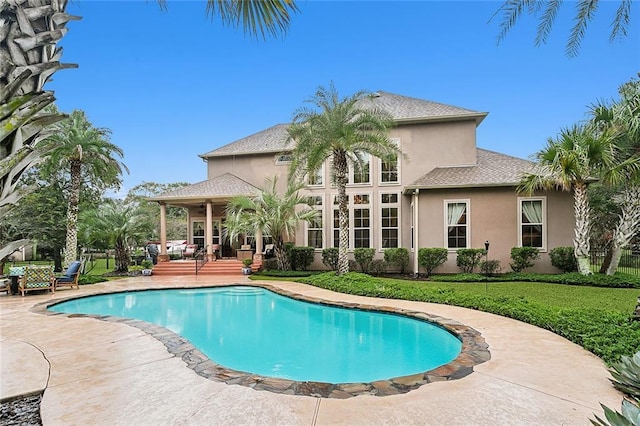 view of pool with a patio and a lawn