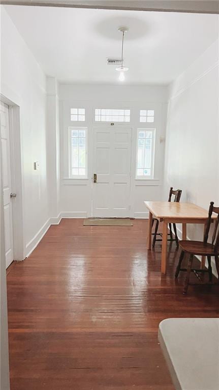 entrance foyer featuring baseboards, a wealth of natural light, and wood finished floors