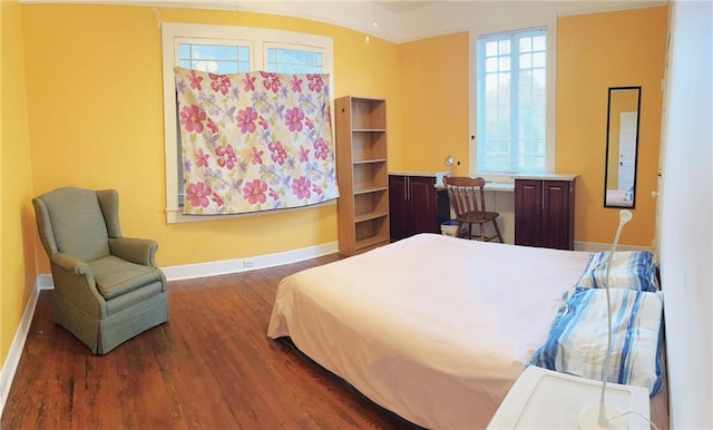 bedroom with baseboards and wood finished floors