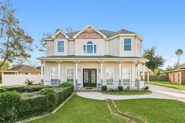 view of front facade with a porch, french doors, and a front lawn