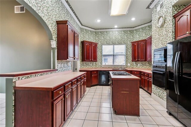 kitchen with a center island, ornamental molding, light tile patterned floors, kitchen peninsula, and black appliances