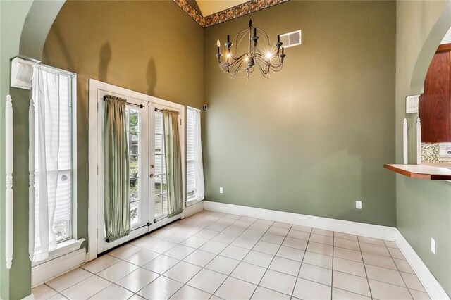 unfurnished dining area featuring light tile patterned flooring and a chandelier