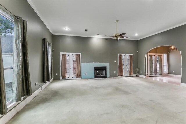 unfurnished living room with french doors, crown molding, a healthy amount of sunlight, and light carpet