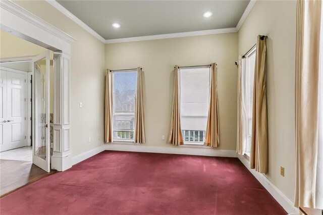 spare room featuring crown molding and carpet flooring