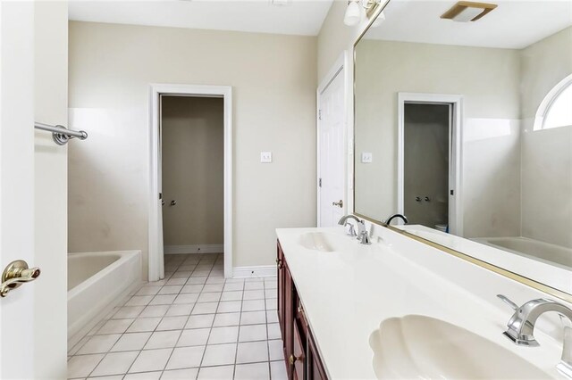 bathroom featuring a washtub, tile patterned floors, and vanity