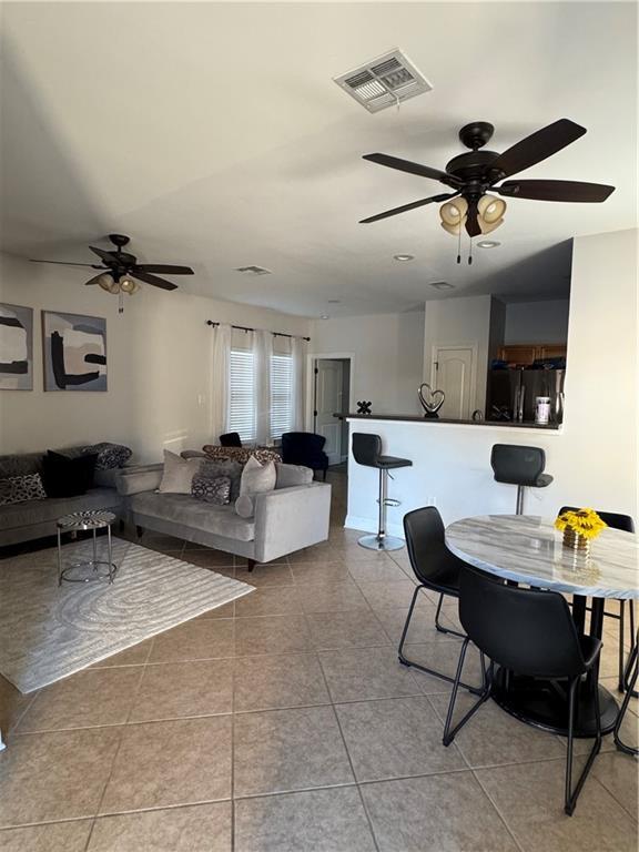 tiled living room with ceiling fan