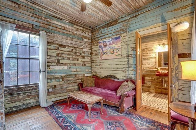 sitting room featuring wooden walls and wooden ceiling