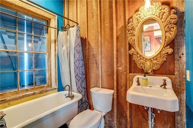 bathroom with sink, a washtub, and toilet