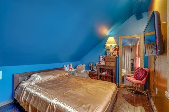 bedroom with lofted ceiling and hardwood / wood-style floors