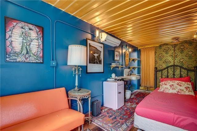 bedroom featuring hardwood / wood-style flooring and a wall mounted air conditioner