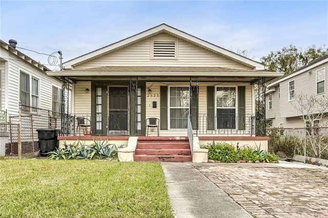 bungalow featuring a porch and a front lawn